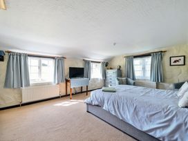 A bedroom with a bed and television at The Old Church House in Torbryan