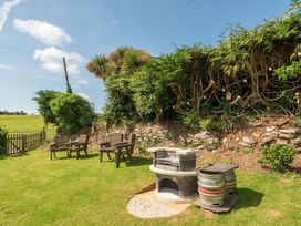 A garden with seating area and barbecue at The Old Church House in Torbryan