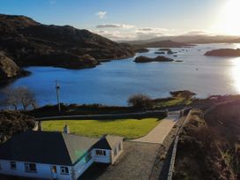 A house with a driveway and gate near water at Ranny Roe in Portsalon, County Donegal