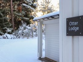 Entry view of Otter Lodge with snow and trees at Otter Lodge in Feshiebridge near Aviemore