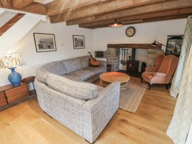 A living room with a sofa and guitar at Kernyk in Rinsey near Porthleven