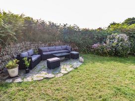 A garden with a sofa set and flower pot at Kernyk in Rinsey near Porthleven