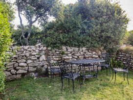 A garden with a table and chairs near a stone wall at Kernyk in Rinsey near Porthleven