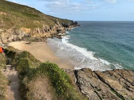 A beach with sand and ocean waves at Kernyk in Rinsey near Porthleven