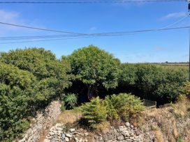 A garden area with trees and a stone wall at Kernyk Rinsey near Porthleven