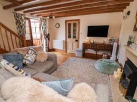 A living room with a sofa and television at Ash Farm Cottage Lixwm near Caerwys