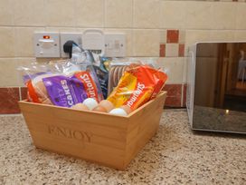 A basket with eggs and snacks on a countertop at Ash Farm Cottage in Lixwm near Caerwys