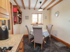 A kitchen with a dining table and chairs at Ash Farm Cottage in Lixwm near Caerwys