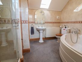 A bathroom with a shower, sink, toilet, and bathtub at Ash Farm Cottage in Lixwm near Caerwys