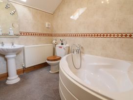 A bathroom with a bathtub, sink, and toilet at Ash Farm Cottage in Lixwm near Caerwys