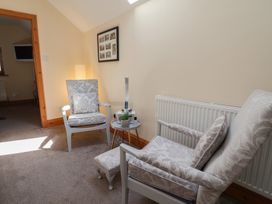A sitting room with two armchairs and a side table at Ash Farm Cottage Lixwm near Caerwys