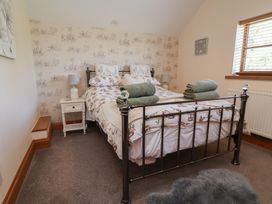 A bedroom with a bed and bedside table at Ash Farm Cottage in Lixwm near Caerwys