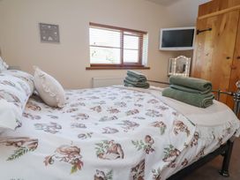 A bedroom with a bed and towels at Ash Farm Cottage in Lixwm near Caerwys