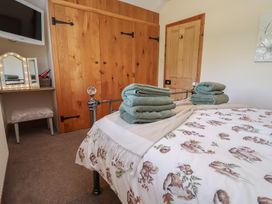 A bedroom with a bed and towels at Ash Farm Cottage in Lixwm near Caerwys