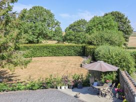 A garden with patio furniture and plants at Ash Farm Cottage in Lixwm near Caerwys