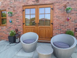 An outdoor seating area with chairs and table at Ash Farm Cottage in Lixwm near Caerwys