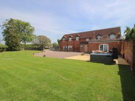 A house with a lawn and hot tub at Hunters Moon in Tenbury Wells