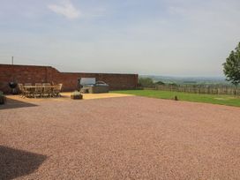 An outdoor area with a table, chairs, and a hot tub at Hunters Moon, Tenbury Wells