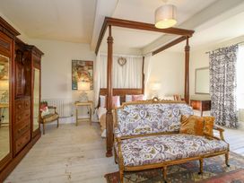 A bedroom with a bed, sofa, and wardrobe at Hilltop House in Tenbury Wells