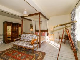A bedroom with a bed, telescope, and sofa at Hilltop House in Tenbury Wells