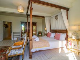 A bedroom with a four-poster bed and a wardrobe at Hilltop House, Tenbury Wells