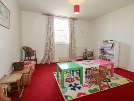 A playroom with a table and chairs at Hilltop House in Tenbury Wells