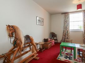 A playroom with a rocking horse and a green table at Hilltop House in Tenbury Wells