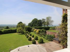 A garden view with trees and hedges at Hilltop House in Tenbury Wells