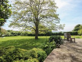 A garden with a tree and bench at Hilltop House in Tenbury Wells