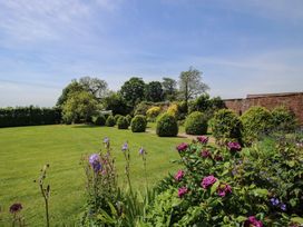 A garden with grass and various plants at Hilltop House in Tenbury Wells