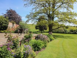A garden with a seating area and flowers at Hilltop House Tenbury Wells