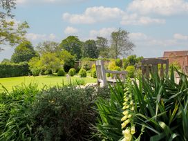 A garden with a wooden bench and green grass at Hilltop House in Tenbury Wells