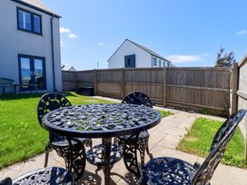 A garden with a table and chairs at The Sand Dunes in Crantock