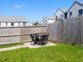 A garden with a table and chairs at The Sand Dunes in Crantock