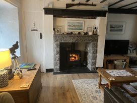 A living room with a fireplace and a television at Tyddyn Serri in Rhosneigr