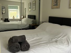 A bedroom with two beds and towels on a bed at Tyddyn Serri in Rhosneigr