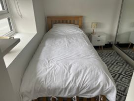 A bedroom with a single bed and a bedside table at Tyddyn Serri in Rhosneigr
