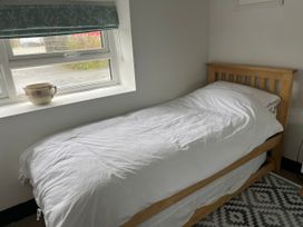 A bedroom with a single bed and a window at Tyddyn Serri Rhosneigr