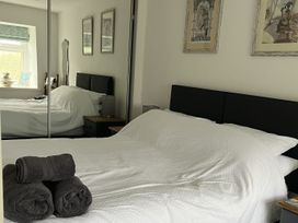 A bedroom with a bed and towels on the side at Tyddyn Serri in Rhosneigr