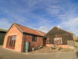 An exterior view of a cottage with patio and garden table at Keepers Cottage in West Knoyle