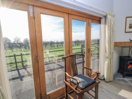 A living room with doors and a chair at Keepers Cottage in West Knoyle