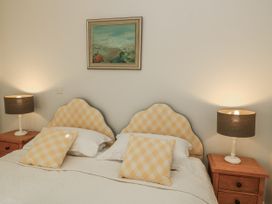 A bedroom featuring a bed with pillows and lamps at Keepers Cottage in West Knoyle