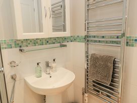 A bathroom with a sink, mirror, and towel rail at Keepers Cottage in West Knoyle