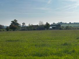 A field with trees and buildings at Keepers Cottage in West Knoyle