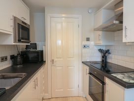A kitchen with a built in oven microwave toaster kettle and cooking utensils at 37 The Salcombe in Salcombe