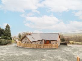 A house with a fence and driveway at Cut Moch, Plas Moelfre Hall Barns Moelfre near Llanrhaeadr-Ym-Mochnant
