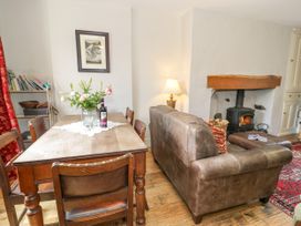 A dining room with a table, chairs, and a sofa at Sygun View in Beddgelert