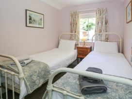 A bedroom with two single beds and a bedside table at Sygun View in Beddgelert