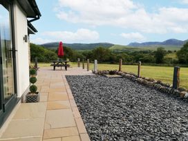 A patio with a picnic table and an umbrella at Cartref Trawsfynydd