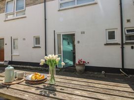 An outdoor table with coffee pot and flowers at 4 Thornlea Mews Hope Cove